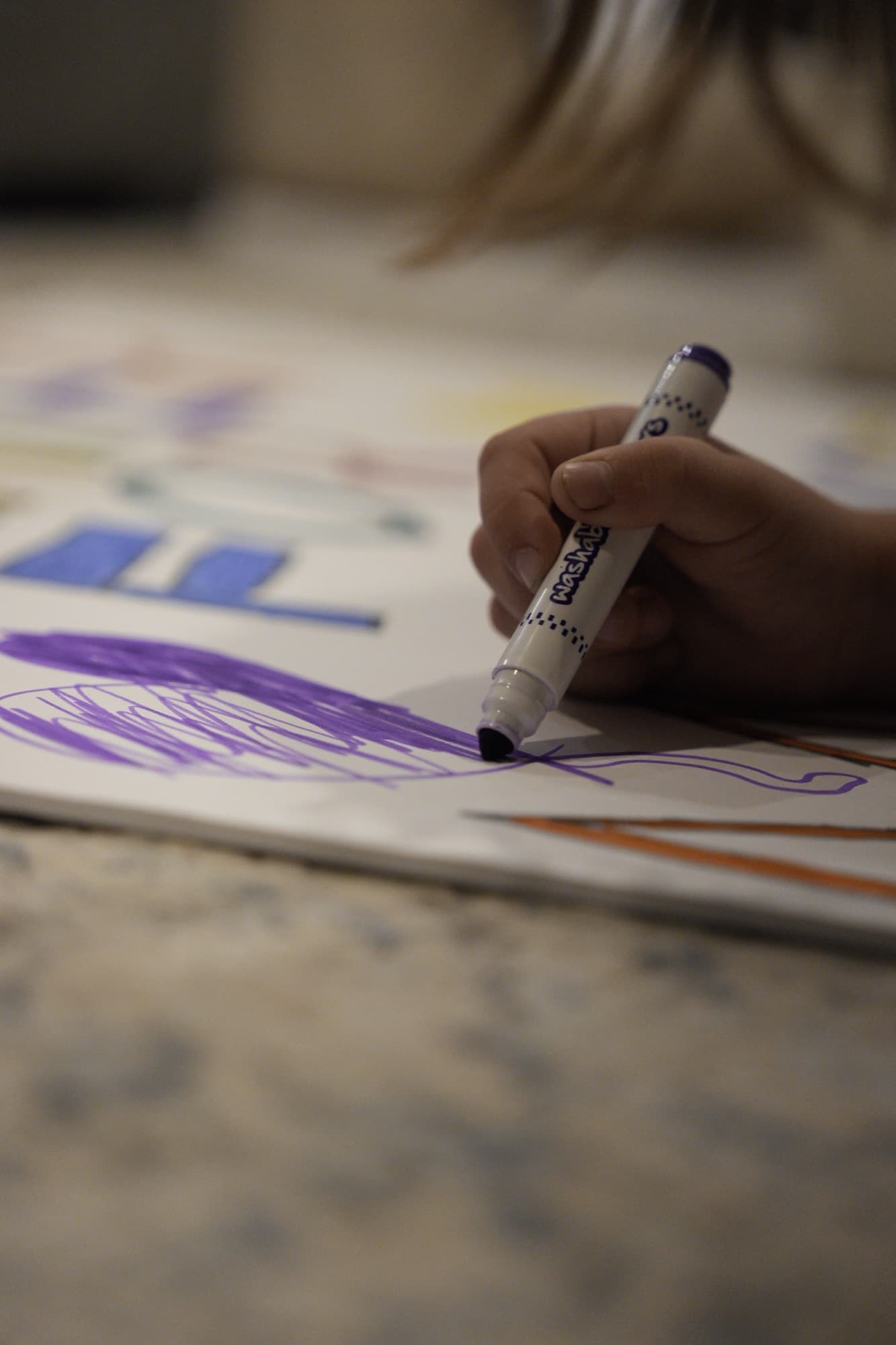 A hand lettering a poster with a marker